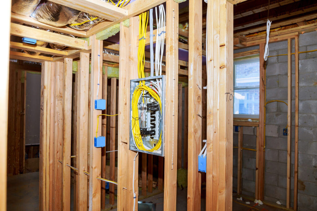 Exposed wood framing and neatly organized wiring completed by experienced electricians in Cohasset.