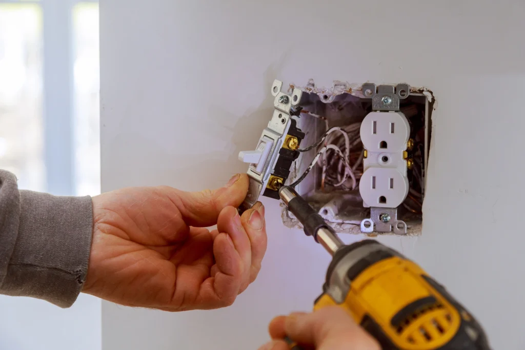 A Weymouth electrician installs electrical switches and outlets in a newly constructed home