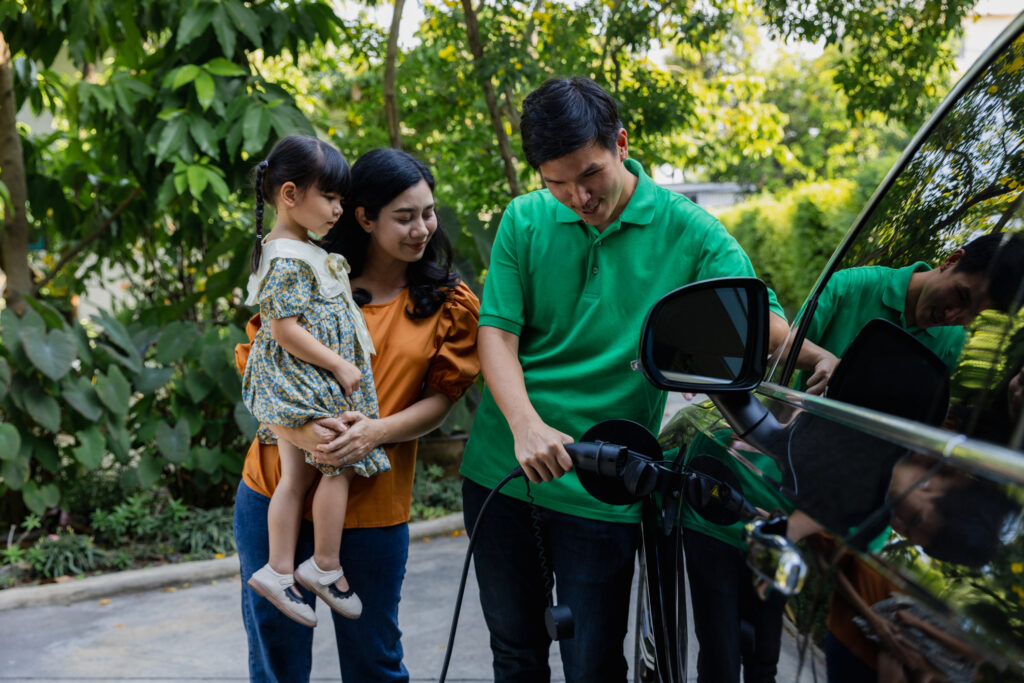 EV Charger Installation at a home with a family gathered around the charger on the vehicle
