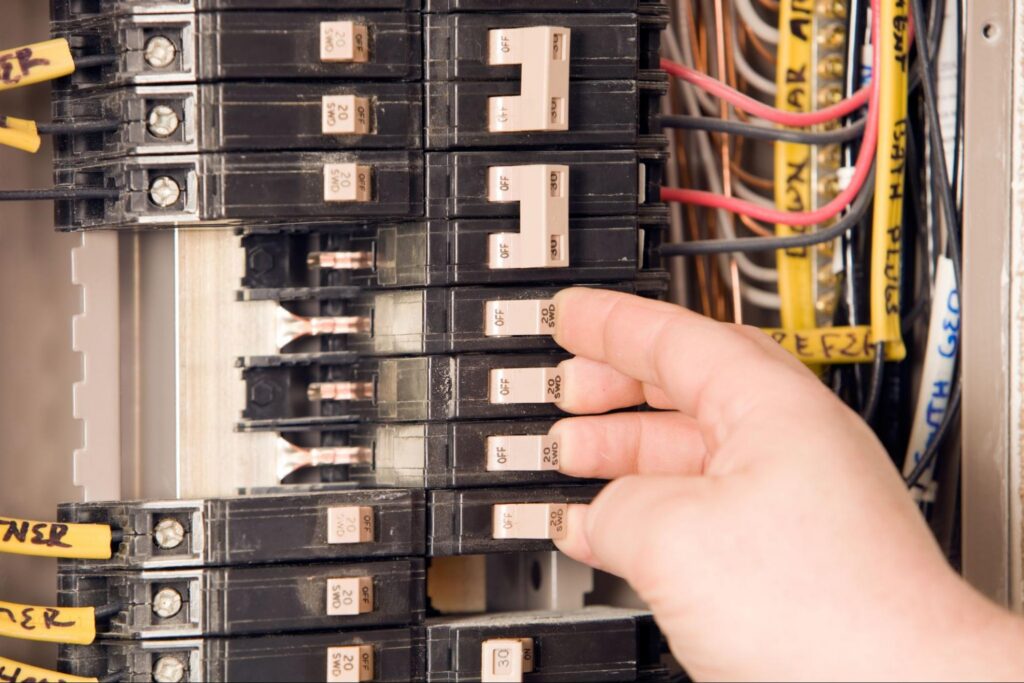 Electrician installing new breakers during an electrical panel replacement, a service for Marshfield, MA homes.