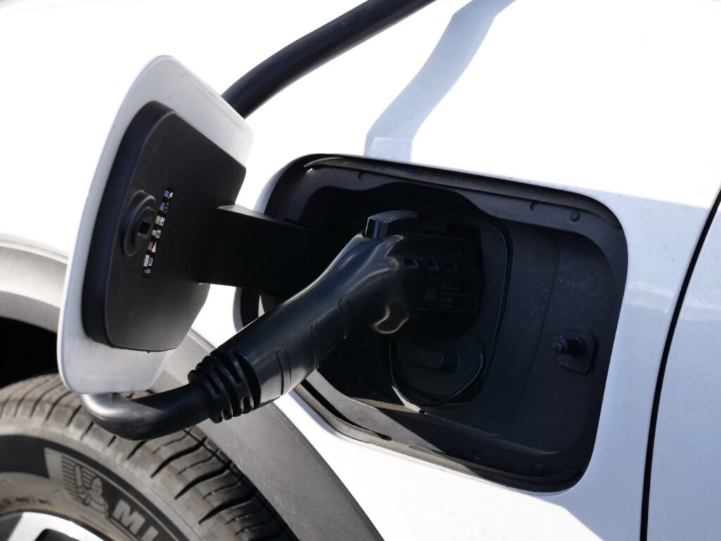A Level 2 plug charging an electric vehicle, typical of home charging in Duxbury, MA.